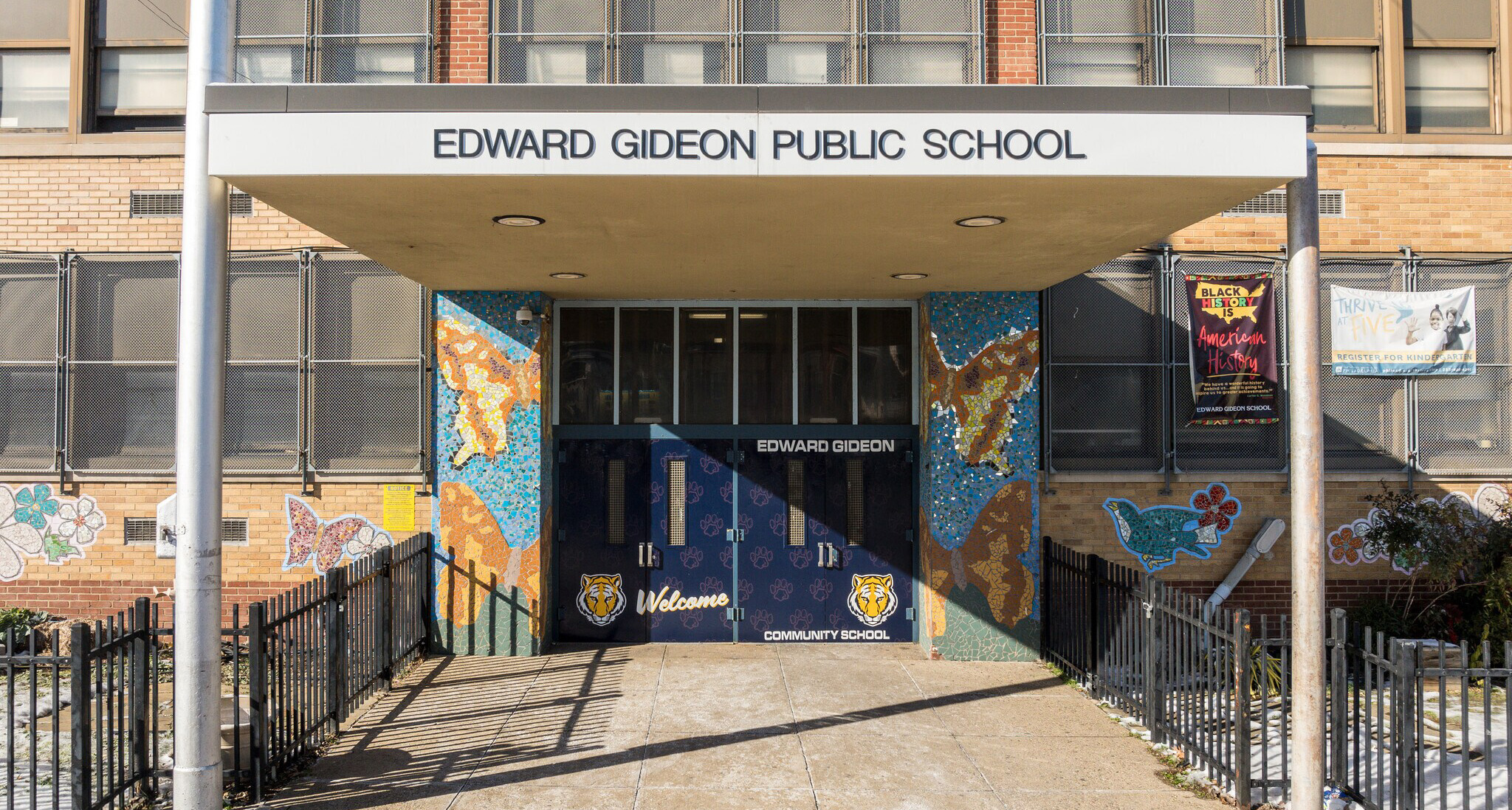 Main entrance of Edward Gideon School featuring colorful mosaic artwork and welcoming tiger graphics.